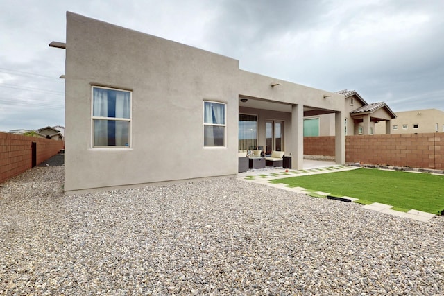 6854 Cleary Loop NE, Rio Rancho, NM 87144 - rear view of house with a fenced backyard, stucco siding, a patio area, and an outdoor living space