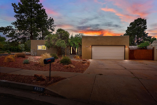 8320 Cherry Hills Dr NE, Albuquerque, NM 87111 - pueblo-style home featuring stucco siding, concrete driveway, and an attached garage