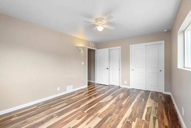 8320 Cherry Hills Dr NE, Albuquerque, NM 87111 - unfurnished bedroom with multiple closets, wood finished floors, baseboards, and a ceiling fan