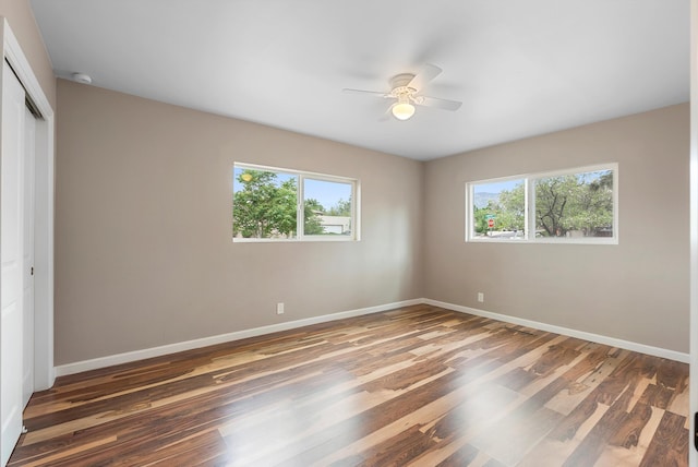 8320 Cherry Hills Dr NE, Albuquerque, NM 87111 - unfurnished bedroom with multiple windows, a closet, baseboards, and wood finished floors
