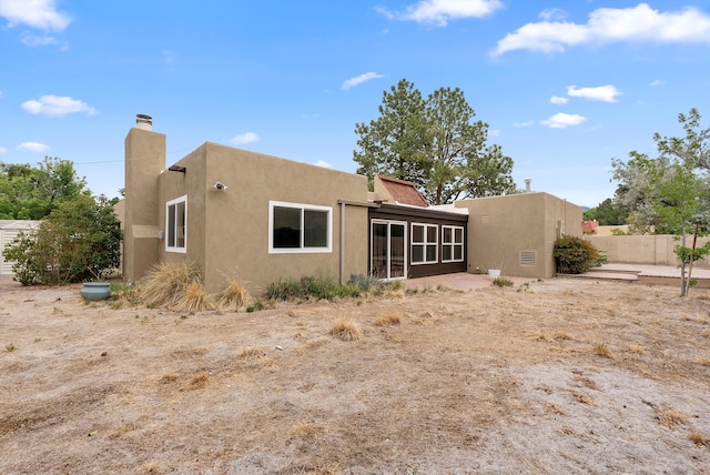 8320 Cherry Hills Dr NE, Albuquerque, NM 87111 - rear view of house featuring a chimney, stucco siding, and a sunroom