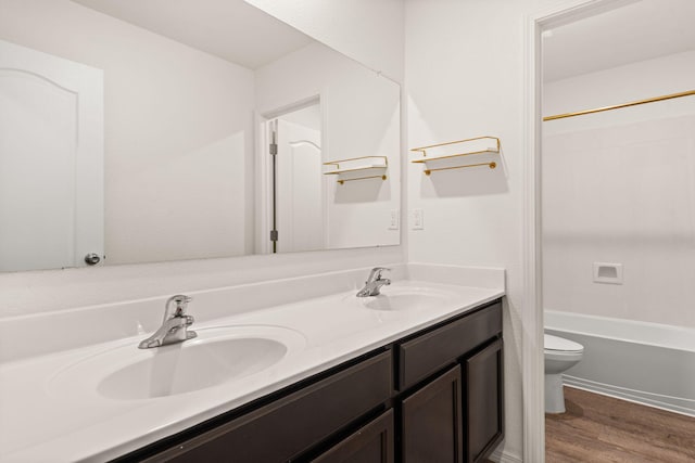 2425 Desi Loop, Belen, NM 87002 - bathroom featuring double vanity, toilet, wood finished floors, and bathing tub / shower combination