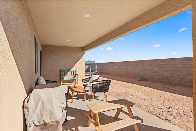 2425 Desi Loop, Belen, NM 87002 - fenced backyard with a trampoline and a patio