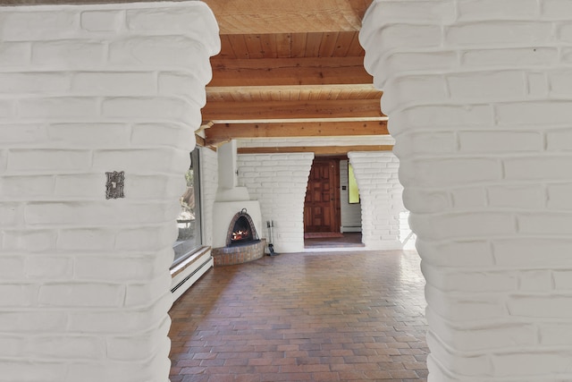 9705 Rio Grande Blvd NW, Albuquerque, NM 87114 - unfurnished living room with wooden ceiling with exposed beams, baseboard heating, brick flooring, and a brick fireplace