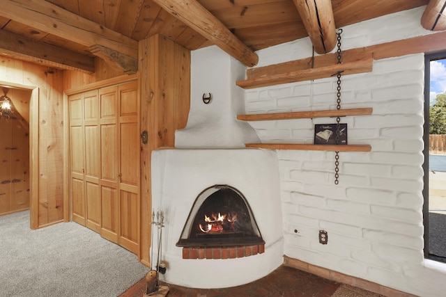 9705 Rio Grande Blvd NW, Albuquerque, NM 87114 - living room with wooden ceiling with exposed beams, a warm lit fireplace, carpet, and wooden walls