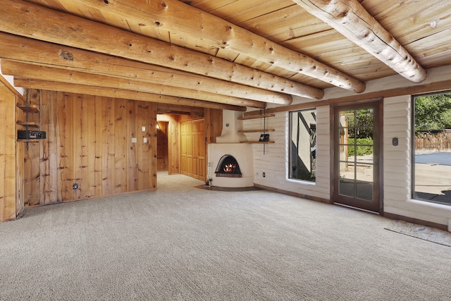 9705 Rio Grande Blvd NW, Albuquerque, NM 87114 - unfurnished living room with wooden ceiling with exposed beams, carpet flooring, wood walls, and a lit fireplace