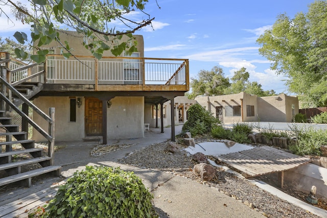 9705 Rio Grande Blvd NW, Albuquerque, NM 87114 - rear view of house featuring stairway, a wooden deck, a patio area, and stucco siding