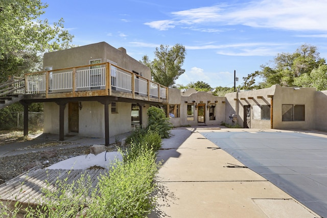 9705 Rio Grande Blvd NW, Albuquerque, NM 87114 - rear view of property featuring a deck, a covered pool, stucco siding, and a patio