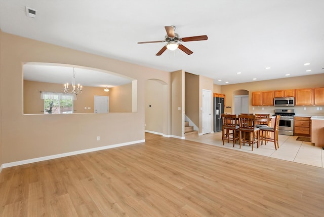 2613 Camino Catalonia SE, Rio Rancho, NM 87124 - living room featuring light wood-style flooring, arched walkways, ceiling fan, and recessed lighting