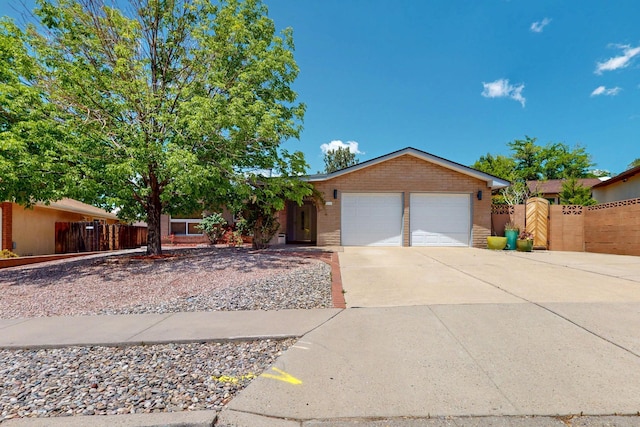 7313 Valley Forge Rd NE, Albuquerque, NM 87109 - single story home with a garage, concrete driveway, brick siding, and a gate
