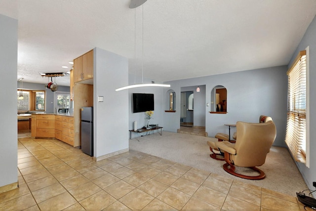 7313 Valley Forge Rd NE, Albuquerque, NM 87109 - living area with light colored carpet, light tile patterned flooring, and arched walkways