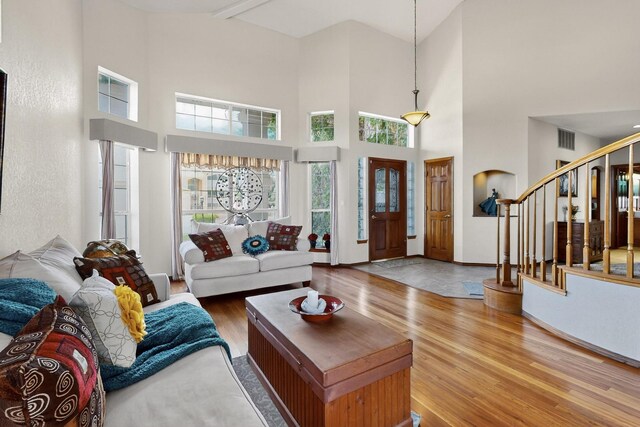 3039 Ashkirk Loop SE, Rio Rancho, NM 87124 - living area with wood finished floors, stairway, healthy amount of natural light, and a towering ceiling