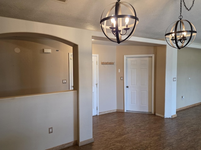 8 Revelations Pl SW, Los Lunas, NM 87031 - unfurnished dining area with a chandelier, wood finished floors, arched walkways, and a textured ceiling