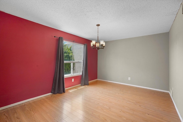 3901 La Frente Ct SE, Rio Rancho, NM 87124 - unfurnished room featuring a chandelier, a textured ceiling, light wood-style floors, and baseboards