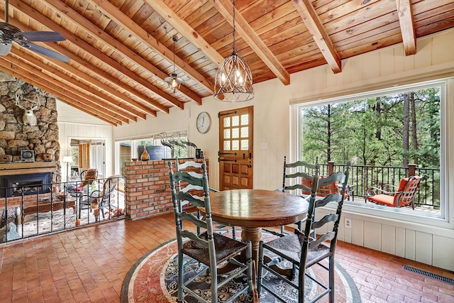 78 Slate Rd, Jemez Springs, NM 87025 - dining room with wood ceiling, brick floors, a chandelier, a fireplace, and a ceiling fan
