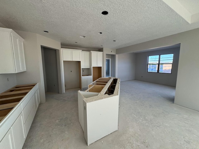 6921 Archer Rd, Rio Rancho, NM 87144 - kitchen featuring a kitchen island, white cabinets, and a textured ceiling