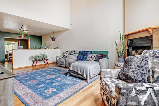 589 Diez Y Ocho Ct SE, Rio Rancho, NM 87124 - living area featuring a towering ceiling, a fireplace, wood finished floors, and a chandelier