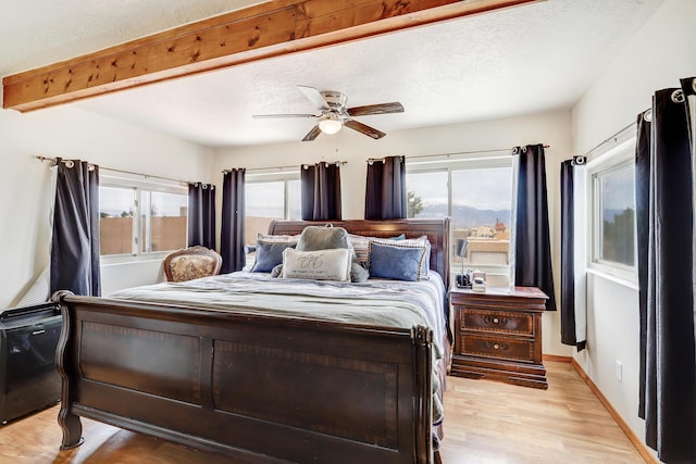 589 Diez Y Ocho Ct SE, Rio Rancho, NM 87124 - bedroom featuring light wood-type flooring, a ceiling fan, beam ceiling, and baseboards