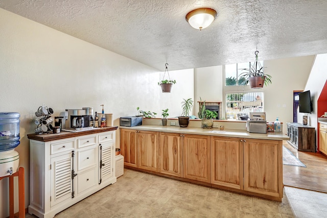589 Diez Y Ocho Ct SE, Rio Rancho, NM 87124 - kitchen featuring a textured ceiling, light countertops, hanging light fixtures, and a peninsula