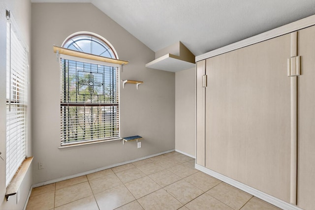 6322 Lamy St NW, Albuquerque, NM 87120 - unfurnished bedroom with lofted ceiling, tile patterned floors, and baseboards