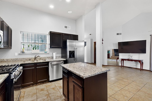 6322 Lamy St NW, Albuquerque, NM 87120 - kitchen with appliances with stainless steel finishes, high vaulted ceiling, a sink, light stone countertops, and light tile patterned flooring