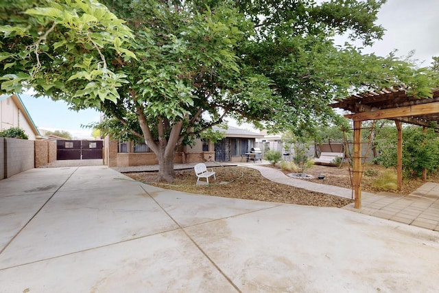 6322 Lamy St NW, Albuquerque, NM 87120 - view of front of home with driveway, a pergola, brick siding, a patio, and a gate