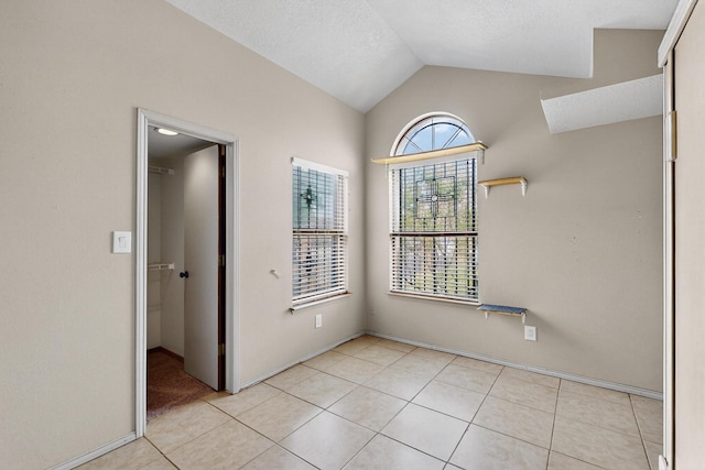 6322 Lamy St NW, Albuquerque, NM 87120 - unfurnished room with lofted ceiling, light tile patterned floors, and baseboards