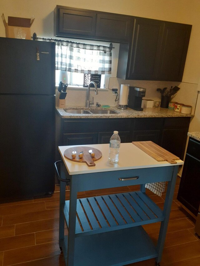 711 Lewis Ave SE, Albuquerque, NM 87102 - kitchen with freestanding refrigerator, wood finish floors, a sink, and light stone counters
