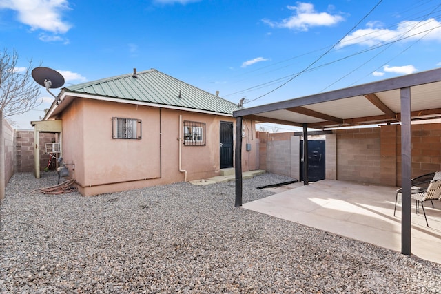 711 Lewis Ave SE, Albuquerque, NM 87102 - rear view of property featuring stucco siding, metal roof, and a gate