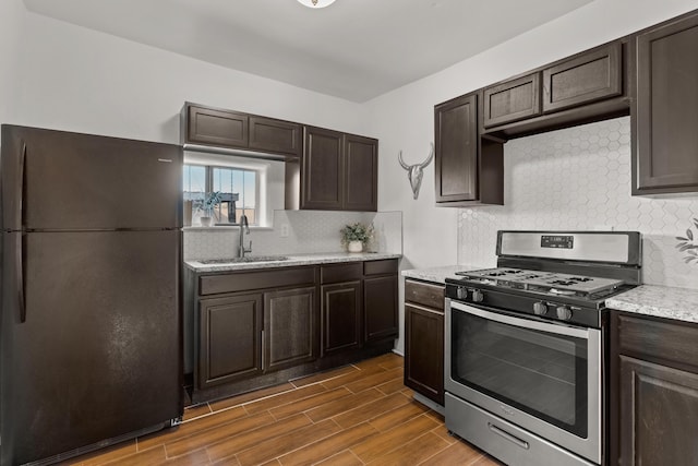 711 Lewis Ave SE, Albuquerque, NM 87102 - kitchen with freestanding refrigerator, gas stove, a sink, and dark brown cabinetry