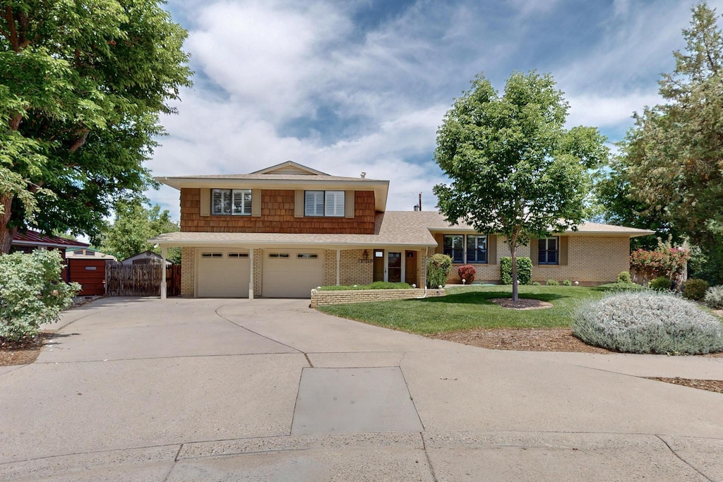 3709 Utah St NE, Albuquerque, NM 87110 - split level home featuring driveway, brick siding, a gate, and an attached garage