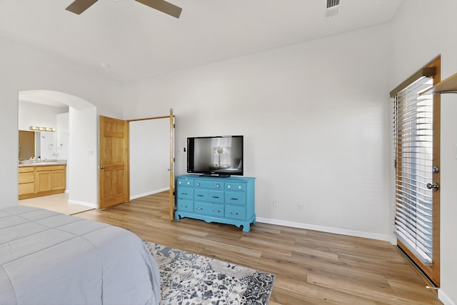 1365 Wilkes Way SE, Rio Rancho, NM 87124 - bedroom featuring light wood finished floors, arched walkways, multiple windows, and baseboards