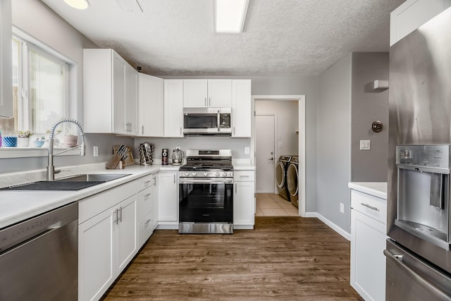1343 San Juan Ct NE, Rio Rancho, NM 87144 - kitchen with stainless steel appliances, washer and dryer, light countertops, dark wood-type flooring, and white cabinets