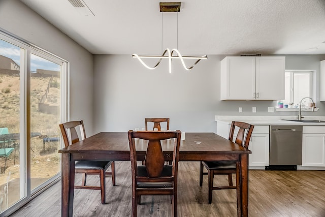 1343 San Juan Ct NE, Rio Rancho, NM 87144 - dining space featuring light wood finished floors and a chandelier