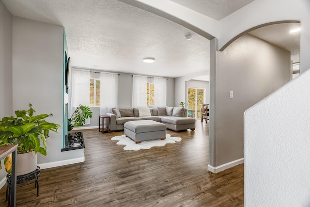 1343 San Juan Ct NE, Rio Rancho, NM 87144 - living room featuring arched walkways, a textured ceiling, plenty of natural light, and wood finished floors