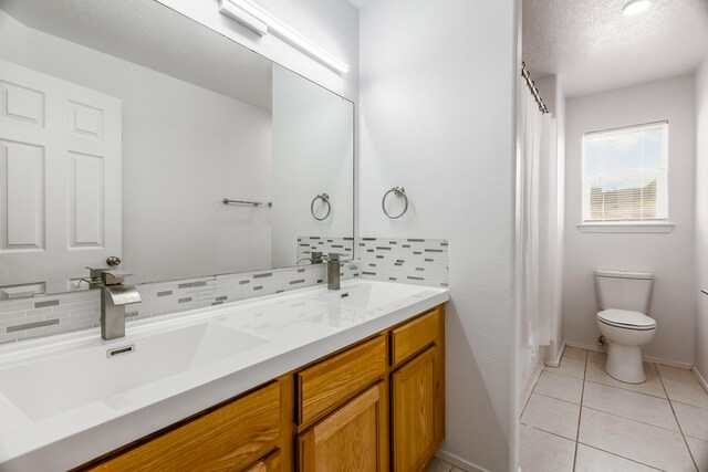 1343 San Juan Ct NE, Rio Rancho, NM 87144 - bathroom with double vanity, tile patterned flooring, decorative backsplash, a shower with curtain, and a textured ceiling