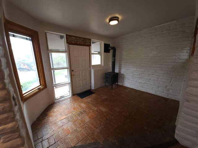 83 Paseo De San Antonio Rd, Placitas, NM 87043 - foyer entrance featuring brick wall, a wood stove, and brick flooring
