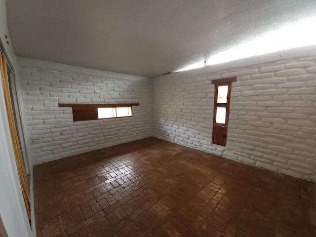 83 Paseo De San Antonio Rd, Placitas, NM 87043 - unfurnished room featuring brick floors and brick wall