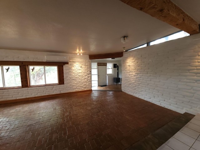 83 Paseo De San Antonio Rd, Placitas, NM 87043 - empty room featuring a wall mounted air conditioner, brick floors, a wood stove, and brick wall