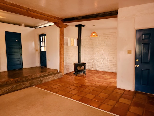 83 Paseo De San Antonio Rd, Placitas, NM 87043 - entryway featuring beam ceiling, a wood stove, tile patterned floors, and brick wall