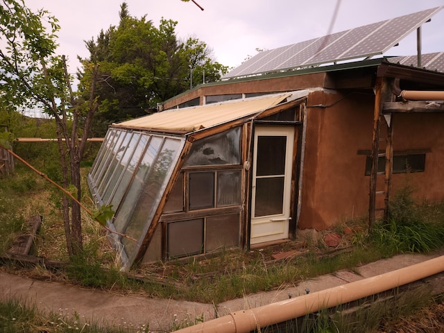 83 Paseo De San Antonio Rd, Placitas, NM 87043 - view of side of property with solar panels, an outdoor structure, and a greenhouse