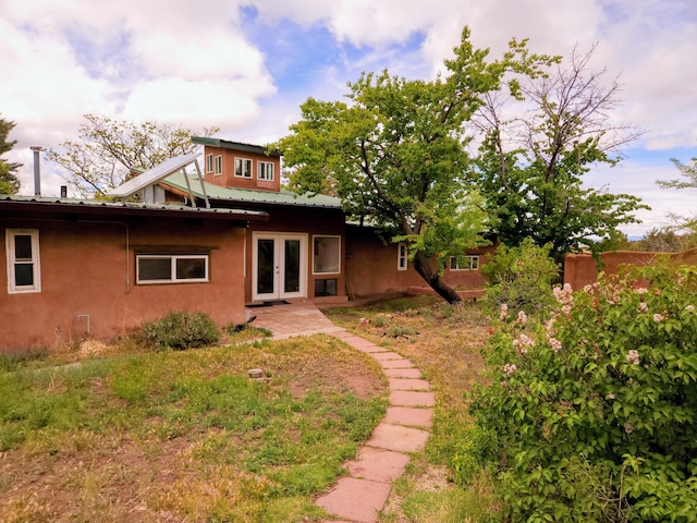83 Paseo De San Antonio Rd, Placitas, NM 87043 - back of house with french doors, stucco siding, and a metal roof
