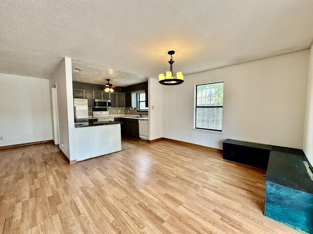 3901 70th St NW, Albuquerque, NM 87120 - kitchen with appliances with stainless steel finishes, light wood-style flooring, baseboards, and a textured ceiling