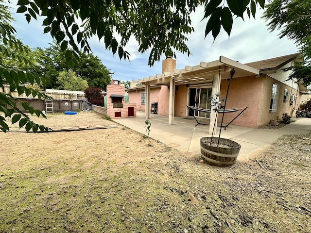 3901 70th St NW, Albuquerque, NM 87120 - rear view of property featuring a chimney, stucco siding, a patio area, and a fireplace