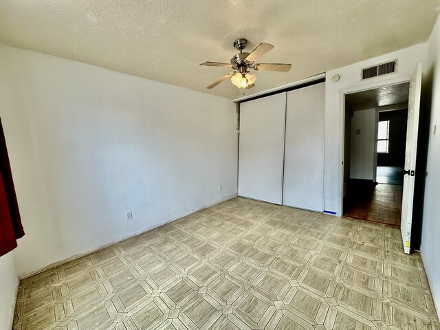 3901 70th St NW, Albuquerque, NM 87120 - unfurnished bedroom featuring a textured ceiling, a closet, and ceiling fan