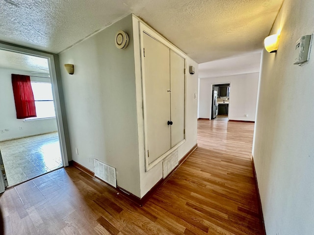 3901 70th St NW, Albuquerque, NM 87120 - corridor with a textured ceiling, wood finished floors, and baseboards