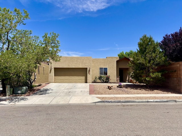 6275 Nueva Espana Rd NW, Albuquerque, NM 87114 - southwest-style home featuring stucco siding, an attached garage, and driveway