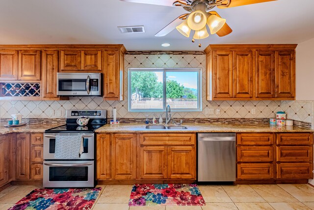 7909 Rancho De Roberto Rd NW, Albuquerque, NM 87114 - kitchen featuring stainless steel appliances, a sink, decorative backsplash, and brown cabinetry