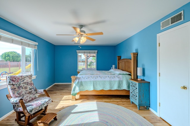 7909 Rancho De Roberto Rd NW, Albuquerque, NM 87114 - bedroom with multiple windows, wood finished floors, a ceiling fan, and baseboards