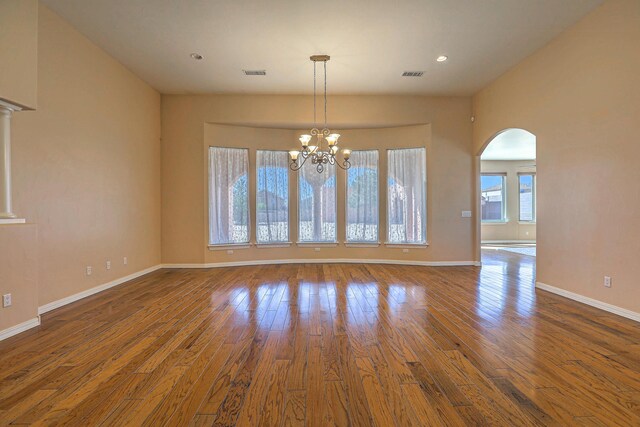 1624 23rd Ave SE, Rio Rancho, NM 87124 - empty room with arched walkways, baseboards, wood finished floors, recessed lighting, and a chandelier